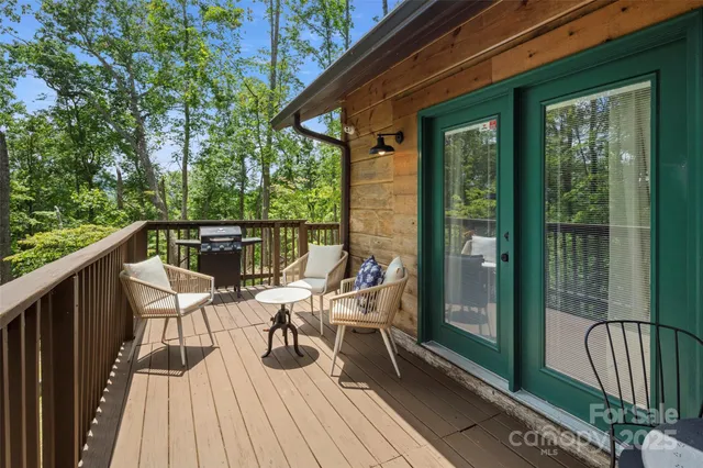 a roof deck with table and chairs under an umbrella