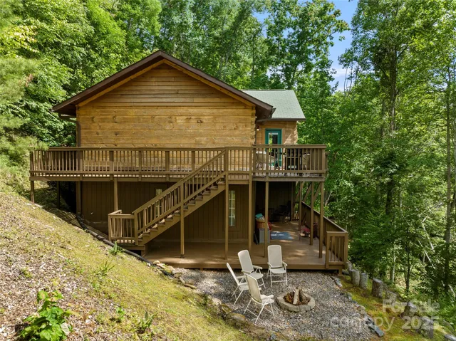 a view of a house with a small yard and large tree