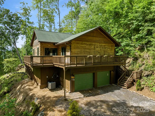 a view of a house with a small yard and a large tree