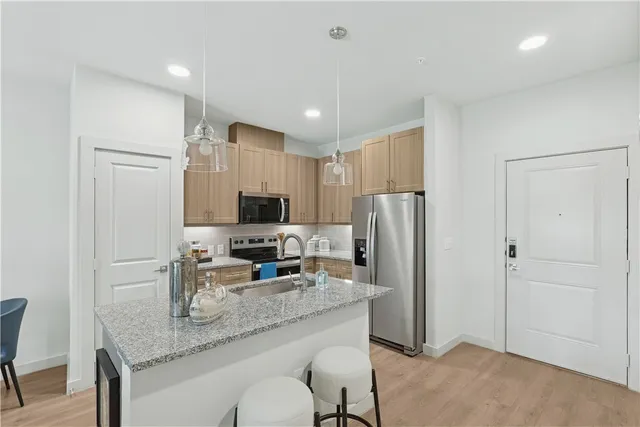 a bathroom with a granite countertop sink toilet tub and shower