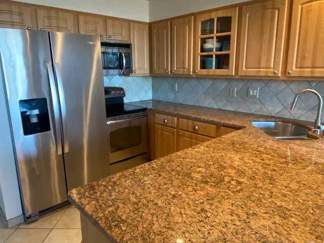 a kitchen with stainless steel appliances granite countertop a refrigerator and a sink