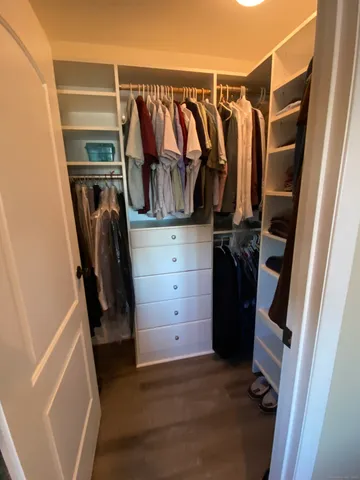 a view of walk in closet with clothes and shoes