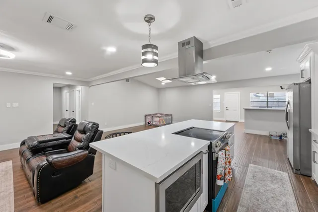 a kitchen with stainless steel appliances granite countertop a sink a stove and a refrigerator