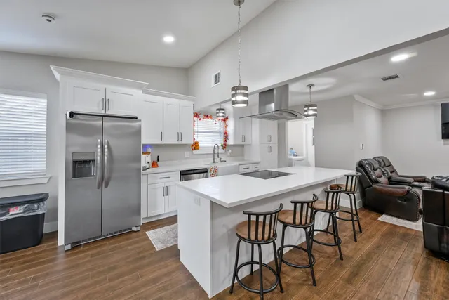 a kitchen with a table chairs refrigerator and microwave