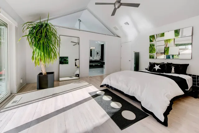 a bedroom with a bed lamp and a large window