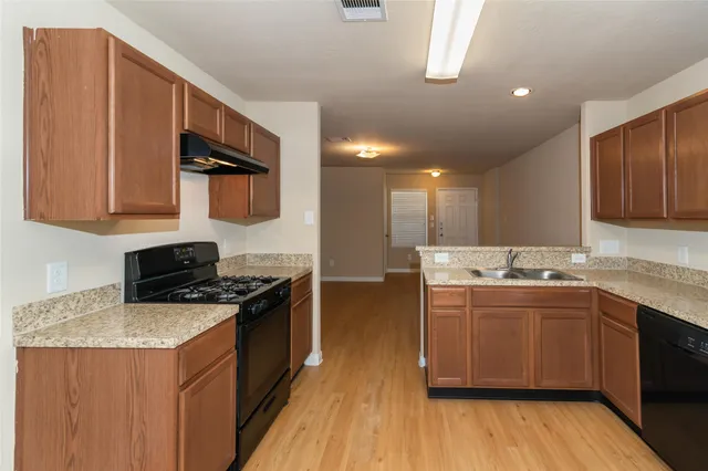 a kitchen with stainless steel appliances granite countertop a stove a sink and a microwave