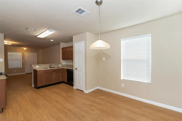 a large kitchen with a window and stainless steel appliances