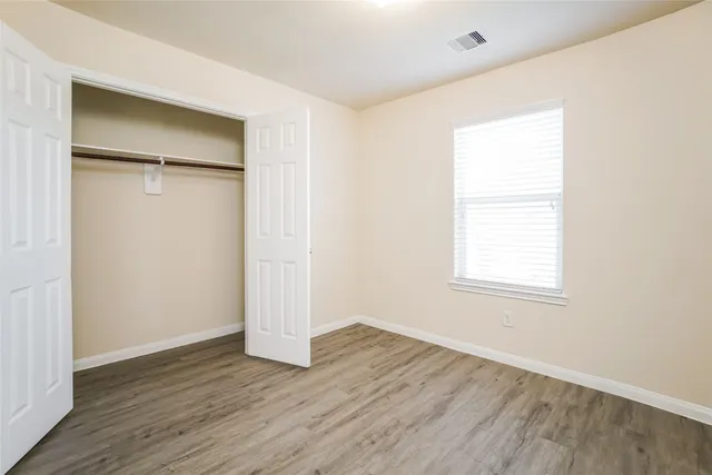 an empty room with wooden floor and a window