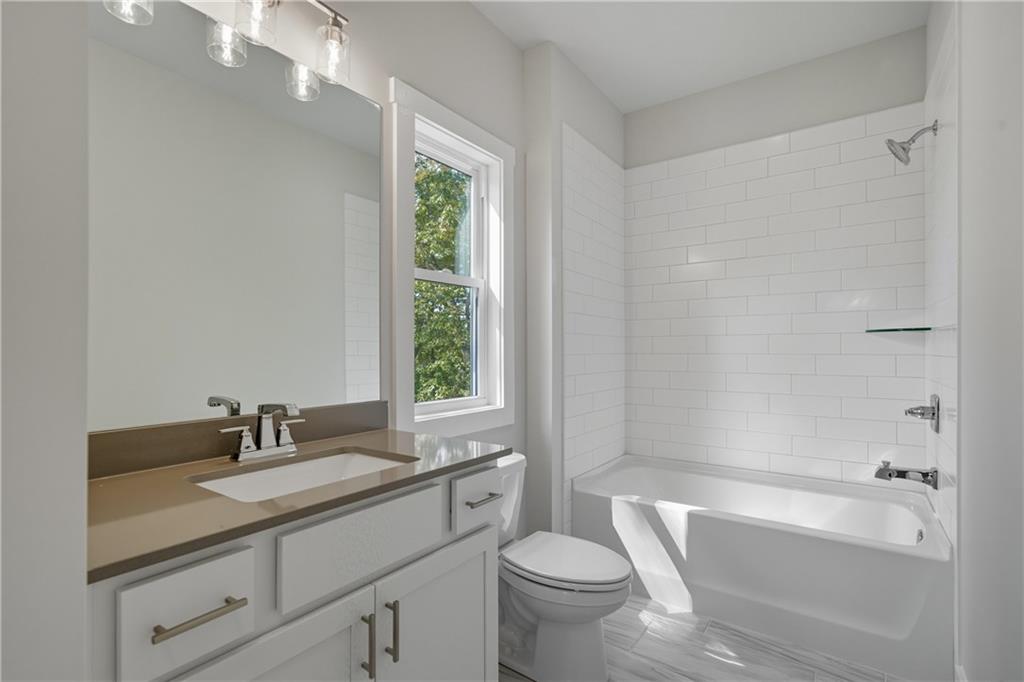 116 Dallas Mark Drive Canton, GA 30115 - Photo 38 of 43 a bathroom with a granite countertop sink a toilet a mirror a bathtub and shower