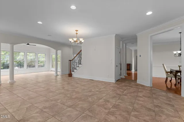 a view of an empty room with wooden floor fireplace and a window