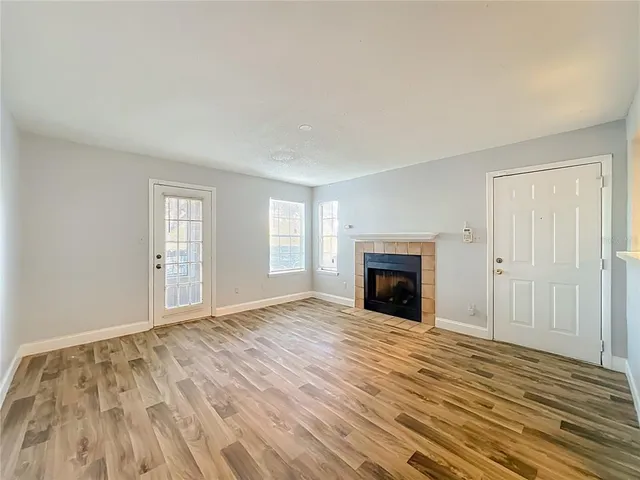 a view of a bedroom with a bed and dresser with wooden floor