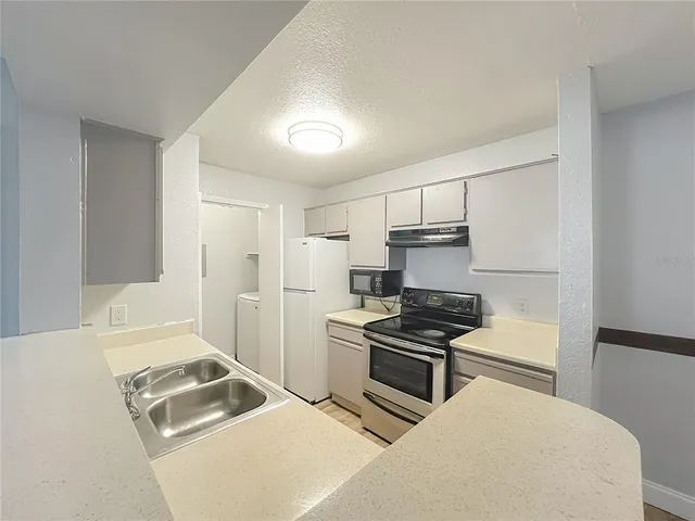 a kitchen with a sink stove and refrigerator