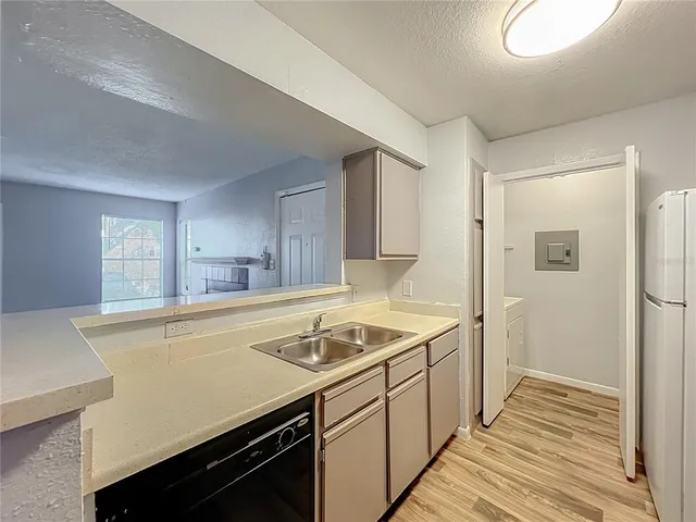 a view of a sink and dishwasher with wooden floor