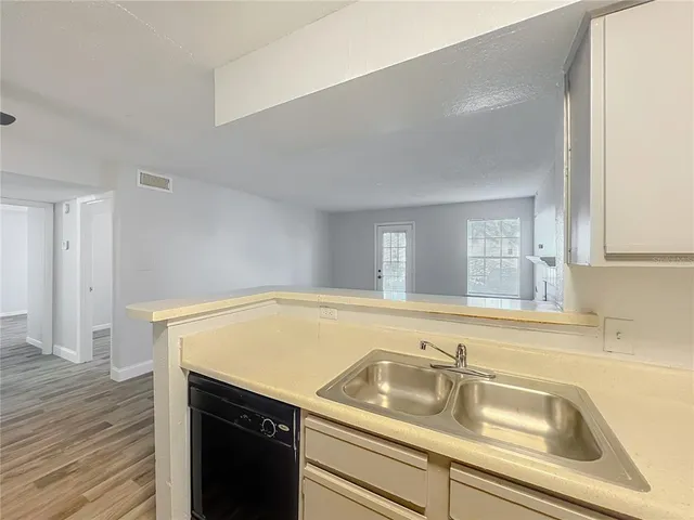 a view of a kitchen cabinets a sink and wooden floor