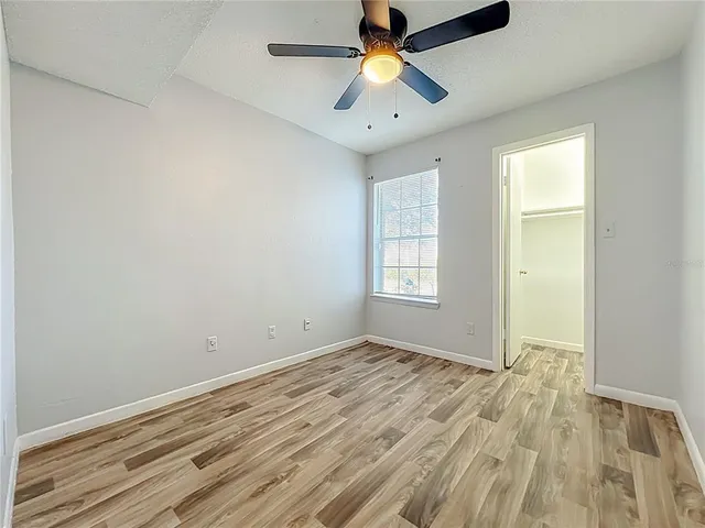 a view of empty room with window and wooden floor