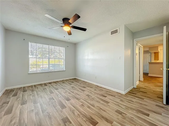 a view of empty room with wooden floor
