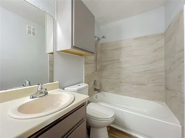 a view of a hallway with wooden floor and windows