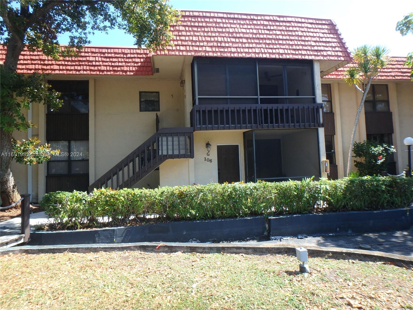 740 Northeast 199th Street, Unit 206G Miami, FL 33179 - Photo 2 of 14 a front view of a house with a yard