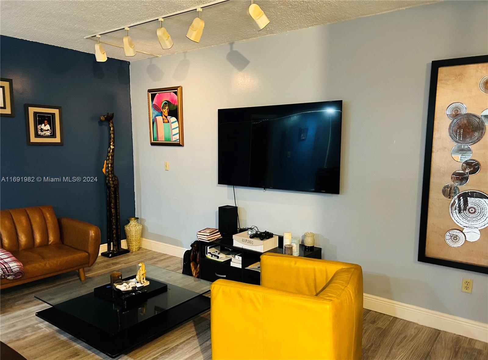 740 Northeast 199th Street, Unit 206G Miami, FL 33179 - Photo 4 of 14 a living room with furniture and a flat screen tv