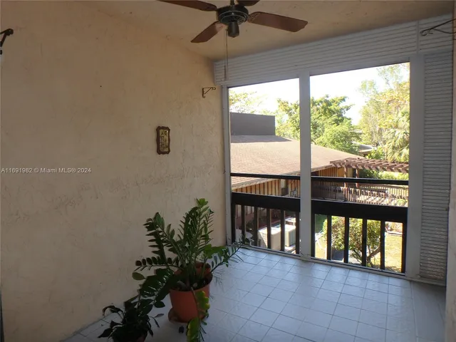 a view of a porch with a floor to ceiling window and a potted plant