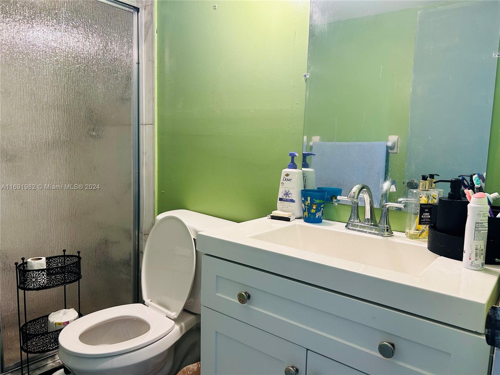 740 Northeast 199th Street, Unit 206G Miami, FL 33179 - Photo 10 of 14 a bathroom with a granite countertop toilet sink and mirror