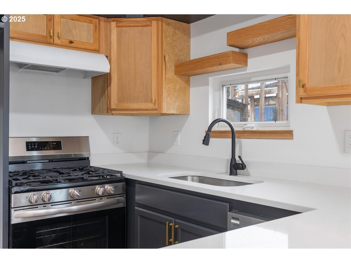 8951 Southeast Fuller Road, Unit 36 Happy Valley, OR 97086 - Photo 9 of 27 a kitchen with stainless steel appliances granite countertop a sink and a stove