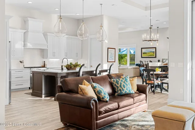 a kitchen with stainless steel appliances granite countertop a dining table chairs and a refrigerator