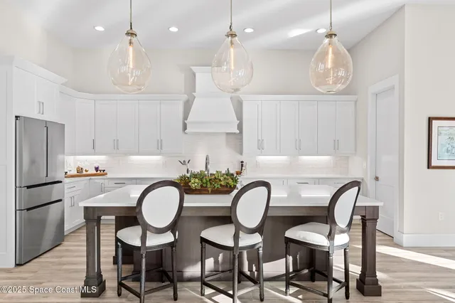 a living room with furniture kitchen view and a wooden floor