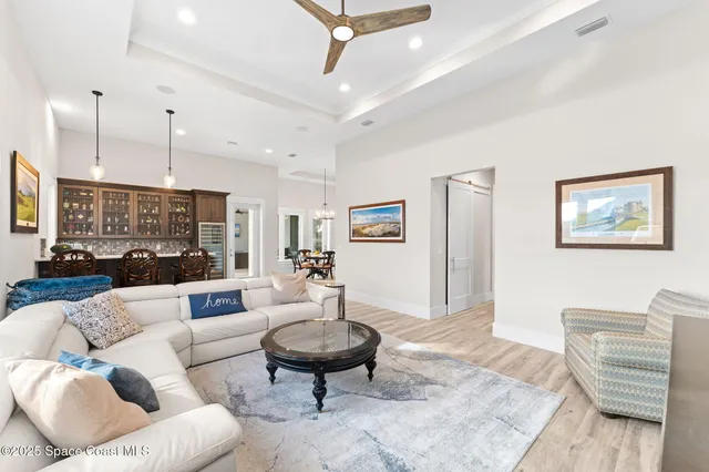 a bedroom with a bed ceiling fan and a wooden floor