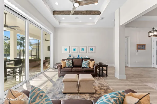 a view of a dining room and livingroom with furniture wooden floor a chandelier