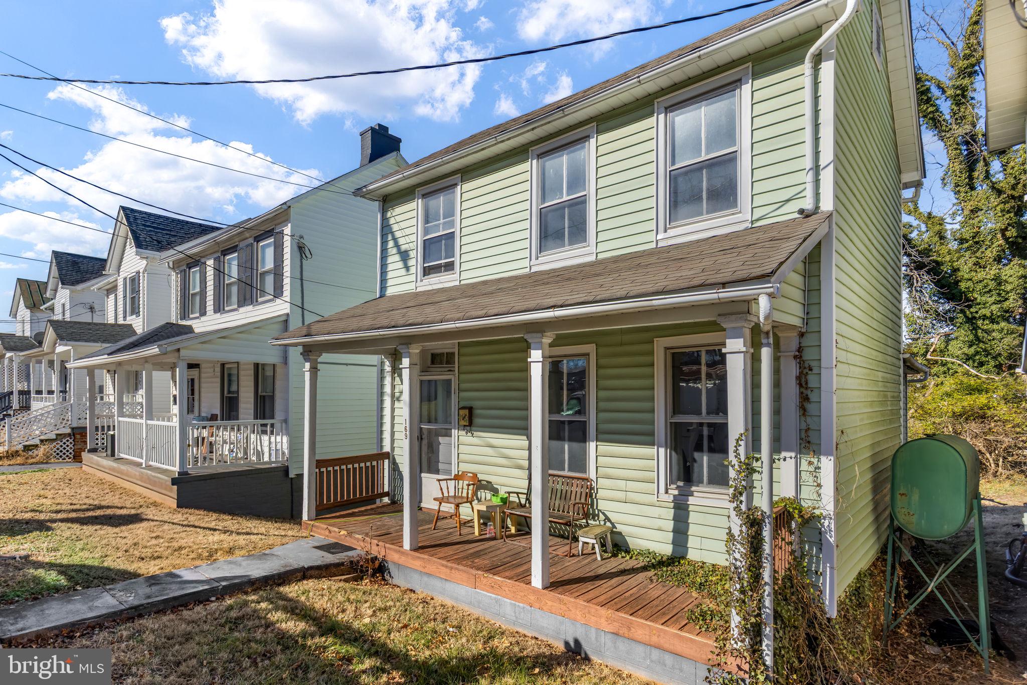 169 East Main Street Orange, VA 22960 - Photo 2 of 27 a view of a brick house with many windows next to a patio
