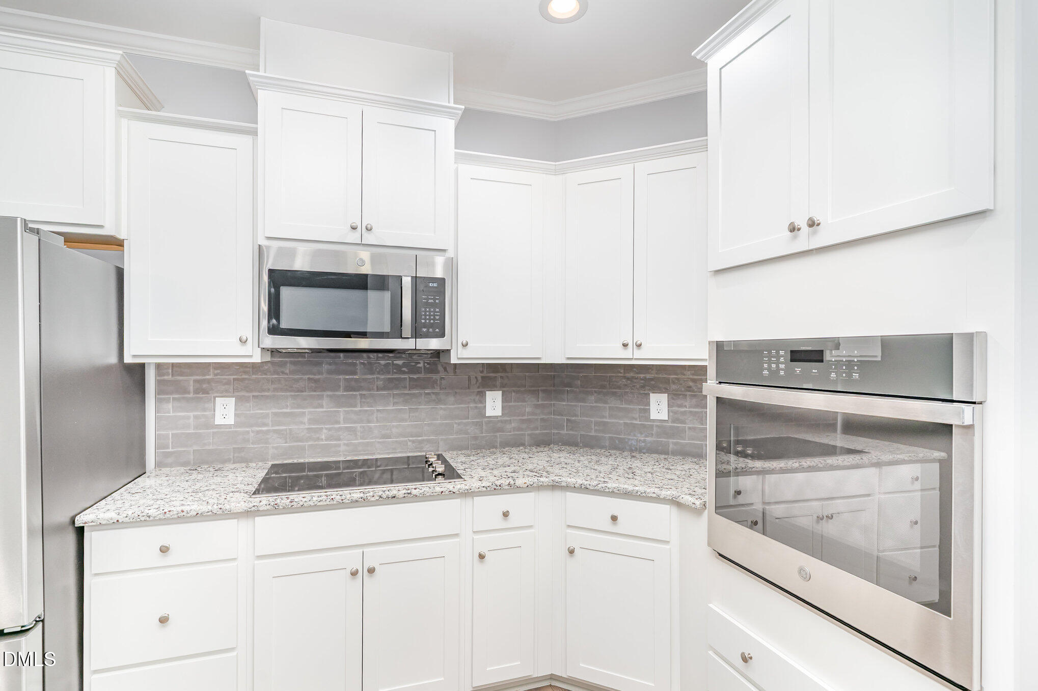 88 Bodacious Lane Benson, NC 27504 - Photo 11 of 32 a kitchen with granite countertop white cabinets and stainless steel appliances
