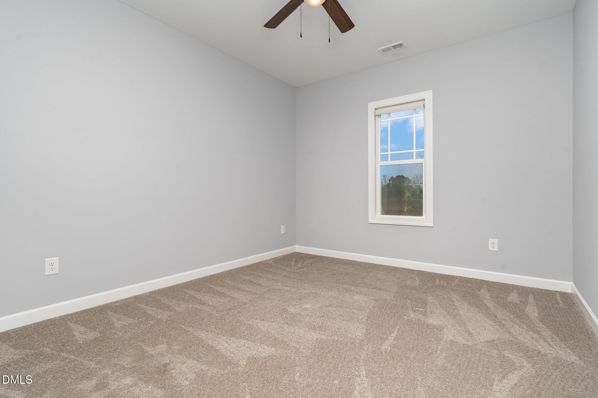 88 Bodacious Lane Benson, NC 27504 - Photo 15 of 32 an empty room with chandelier fan and windows