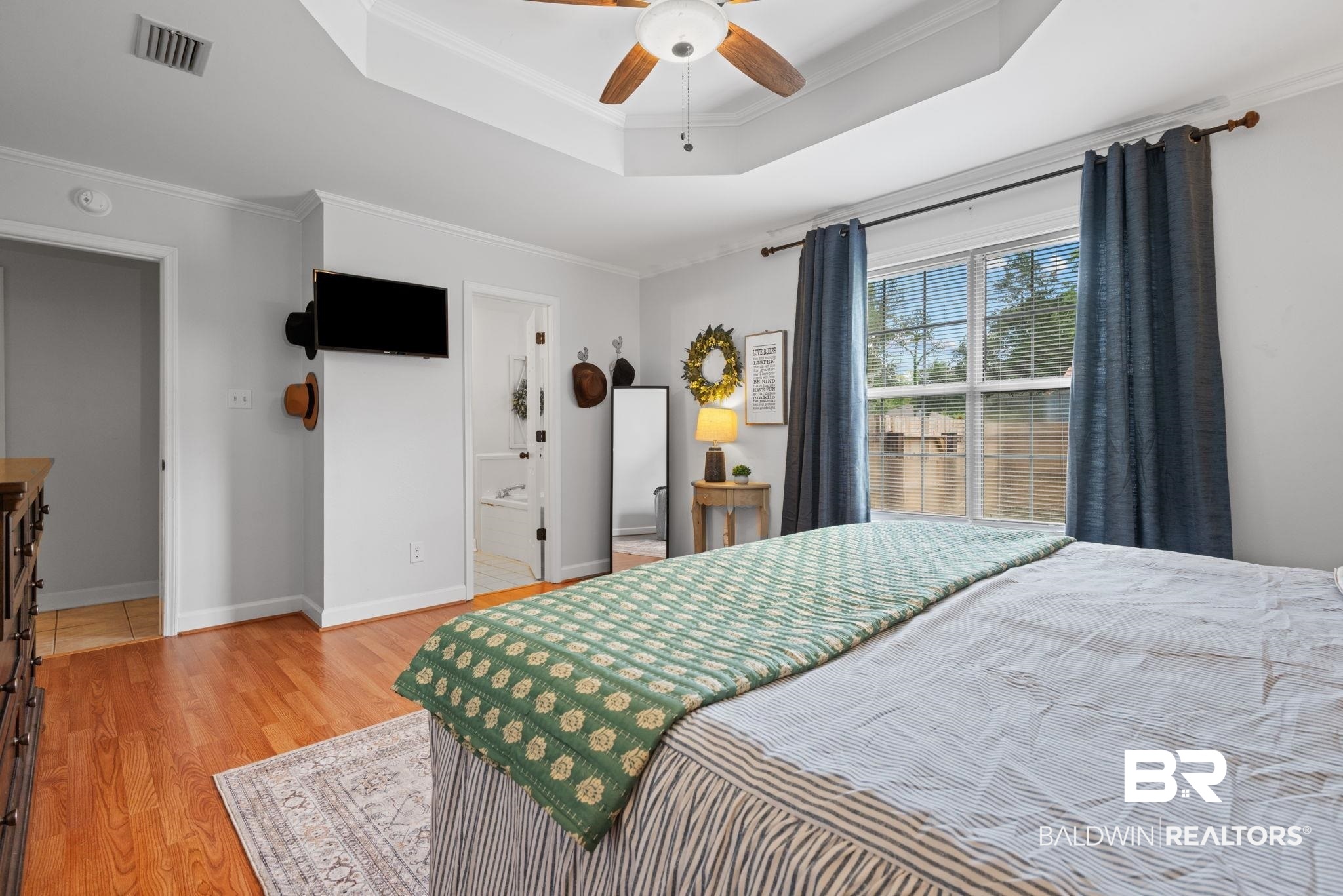 5936 Lundy Road Theodore, AL 36582 - Photo 13 of 32 Spacious room featuring wood-finish flooring, a tray ceiling, and a ceiling fan with integrated lighting
