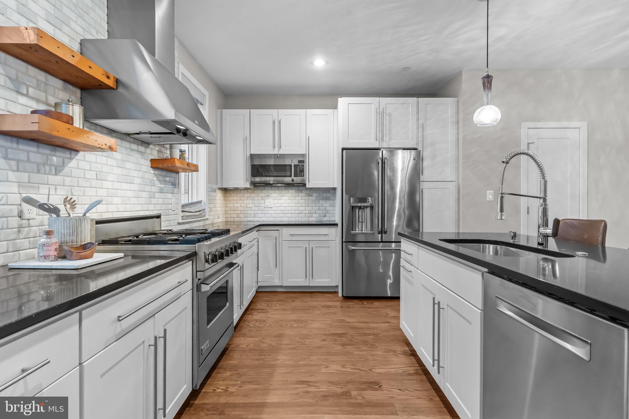 412 Moyer Street, Unit 7 Philadelphia, PA 19125 - Photo 18 of 55 a kitchen with stainless steel appliances granite countertop a sink a stove a refrigerator and cabinets