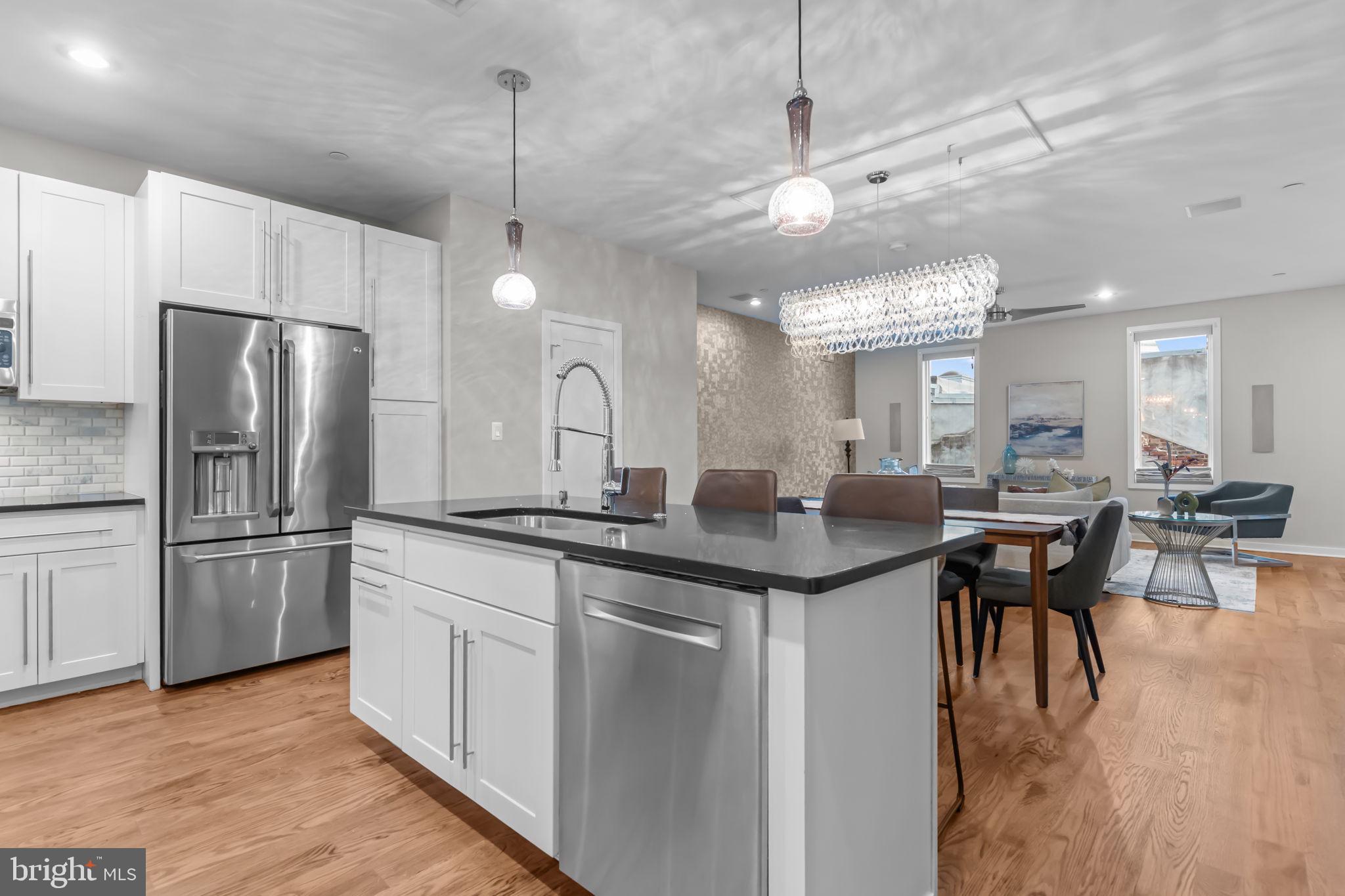 412 Moyer Street, Unit 7 Philadelphia, PA 19125 - Photo 19 of 55 a kitchen with stainless steel appliances granite countertop a sink a stove a refrigerator and island with wooden floor