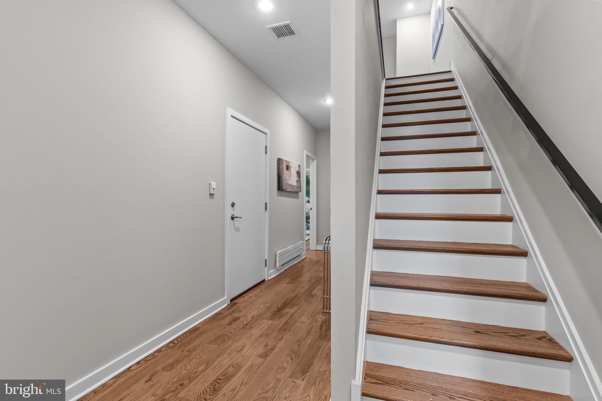412 Moyer Street, Unit 7 Philadelphia, PA 19125 - Photo 4 of 55 a view of staircase with wooden floor and white walls
