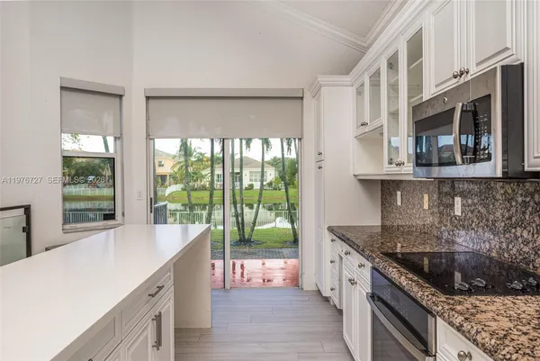 a kitchen with stainless steel appliances granite countertop a sink stove and cabinets