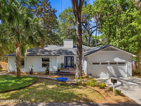 a front view of house with yard and trees in the background