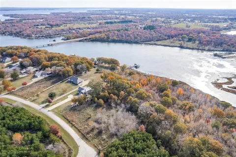 an aerial view of ocean and residential houses with outdoor space