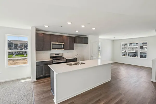 a large kitchen with wooden floor and stainless steel appliances