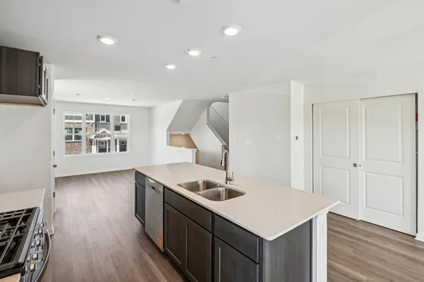 a kitchen with granite countertop a sink and wooden floor