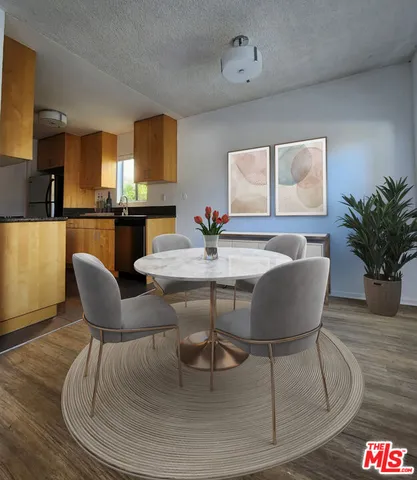 a dining room with furniture a potted plant and wooden floor