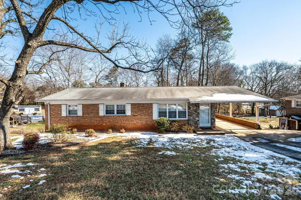a front view of a house with a yard covered with trees