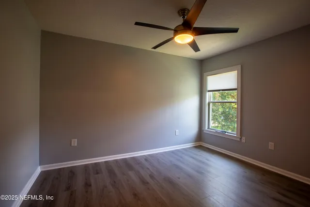 an empty room with window and fan