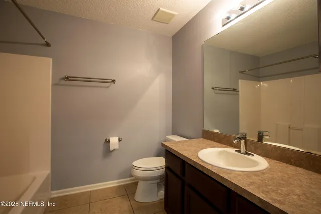 a bathroom with a granite countertop sink toilet and a mirror