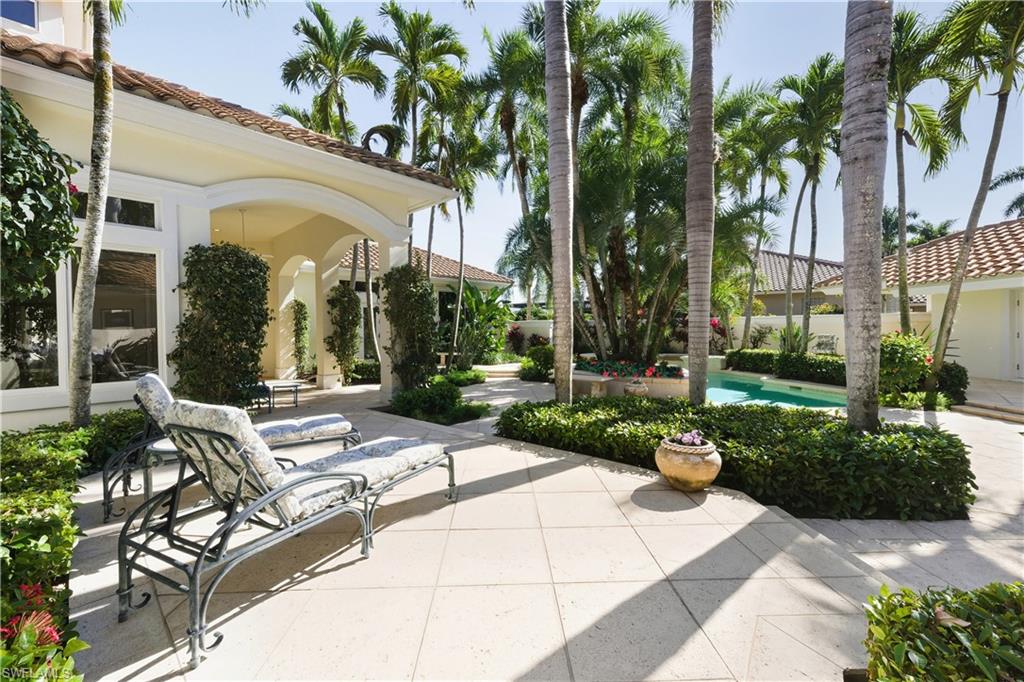 9264 Sweetgrass Way Naples, FL 34108 - Photo 11 of 40 a view of a patio with a table and chairs under an umbrella
