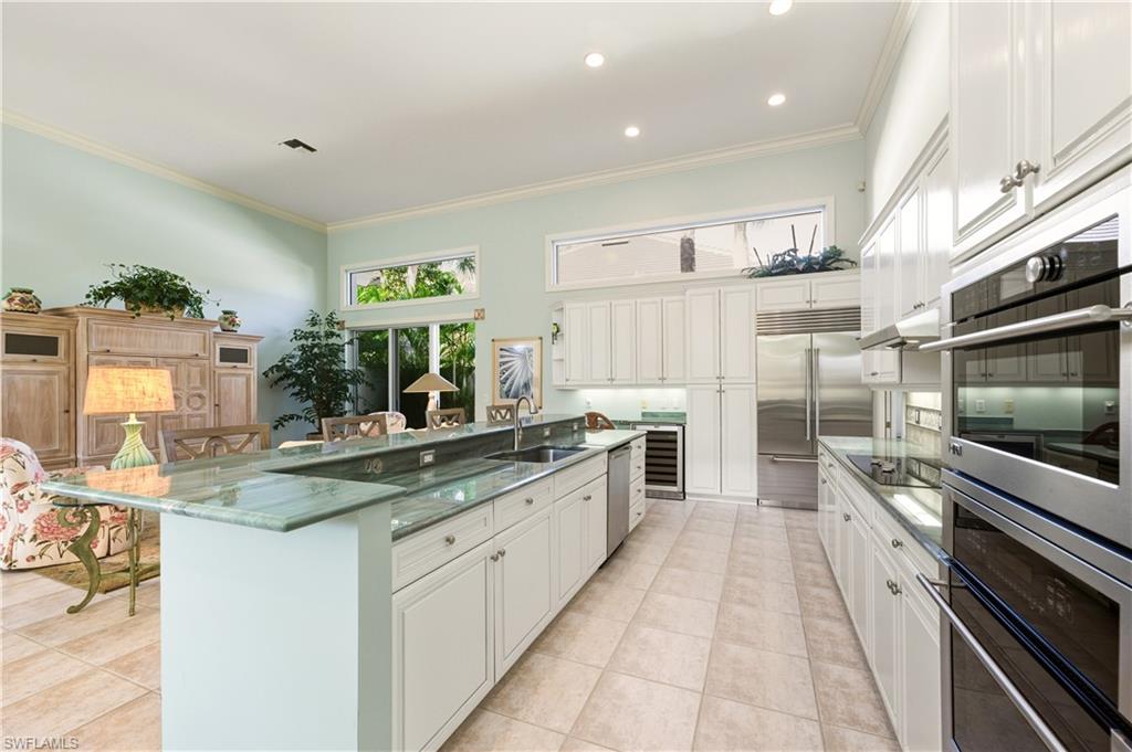 9264 Sweetgrass Way Naples, FL 34108 - Photo 20 of 40 a kitchen with stainless steel appliances granite countertop a sink and stove