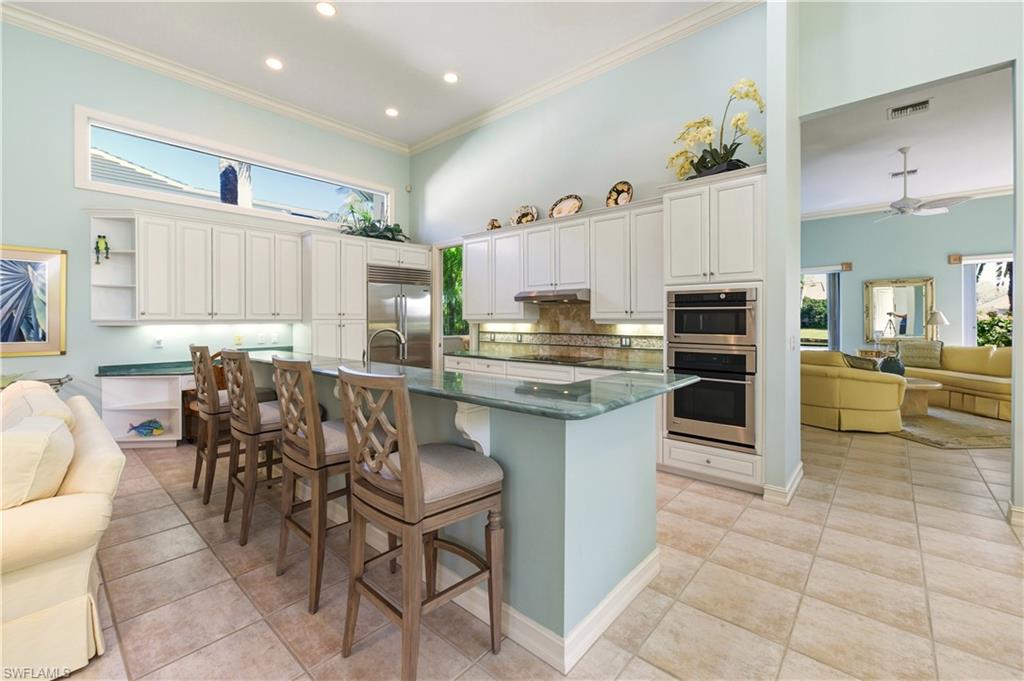 9264 Sweetgrass Way Naples, FL 34108 - Photo 40 of 40 a kitchen with granite countertop a table chairs microwave and cabinets