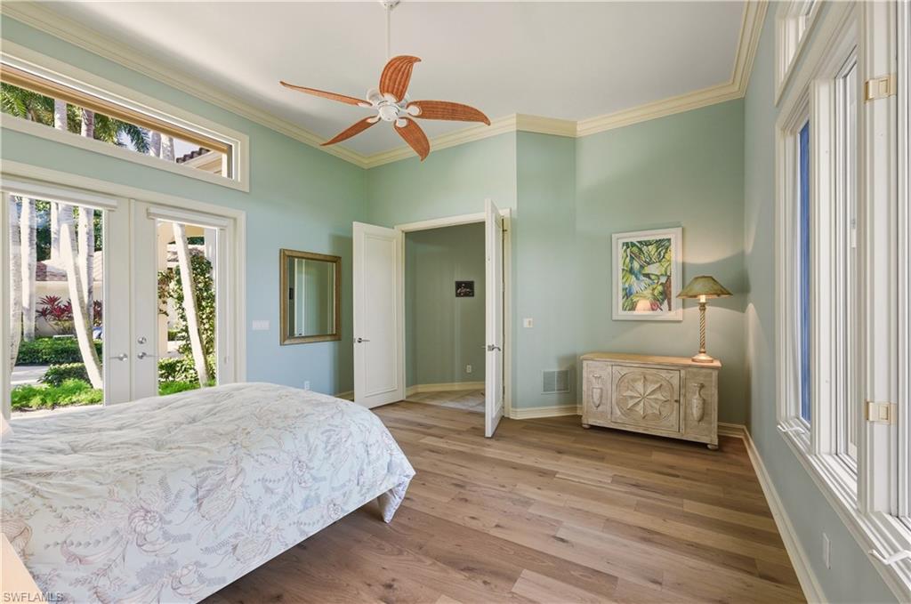 9264 Sweetgrass Way Naples, FL 34108 - Photo 24 of 40 a bedroom with a bed and a chandelier